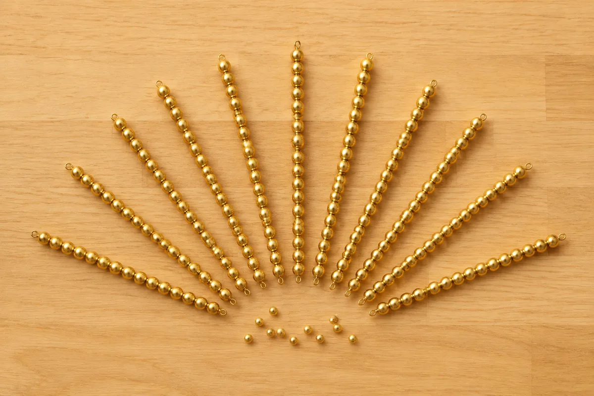 Chaînes de perles dorées disposées en éventail sur une table basse en bois clair